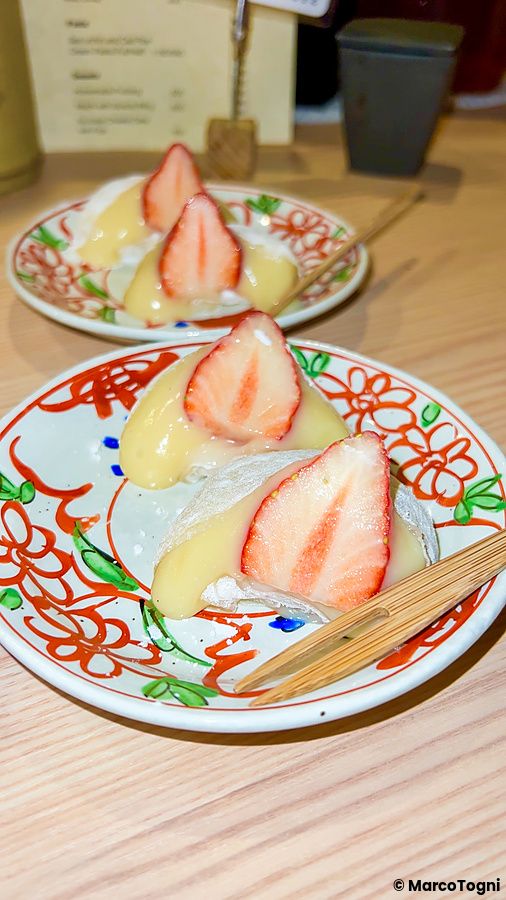 Due porzioni di daifuku con fragole fresche servite su piattini decorati presso l'izakaya Shibuya Kito Kito a Shibuya.