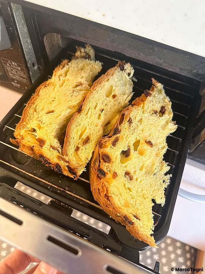 Tre fette di panettone in Giappone, acquistato da DonQ a Tokyo, disposte su una griglia all'interno di un forno elettrico.