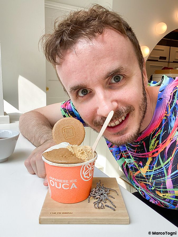 Marco Togni sorride accanto a un gelato con alghe leggermente salate servito in un contenitore arancione presso Ouca a Ebisu.