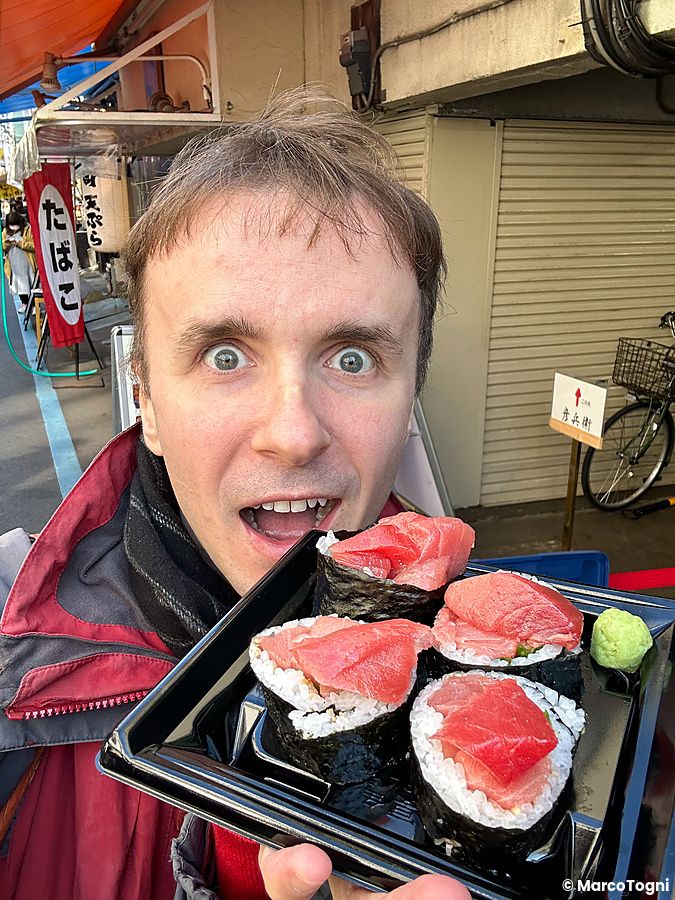 Marco Togni tiene in mano una confezione di maki con tonno acquistata presso la bancarella Maguro Koya a Tsukiji.