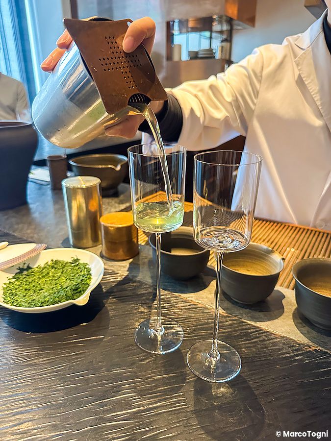 Un addetto versa il tè verde in un calice di vetro presso il Sakurai Japanese Tea Experience a Omotesando.