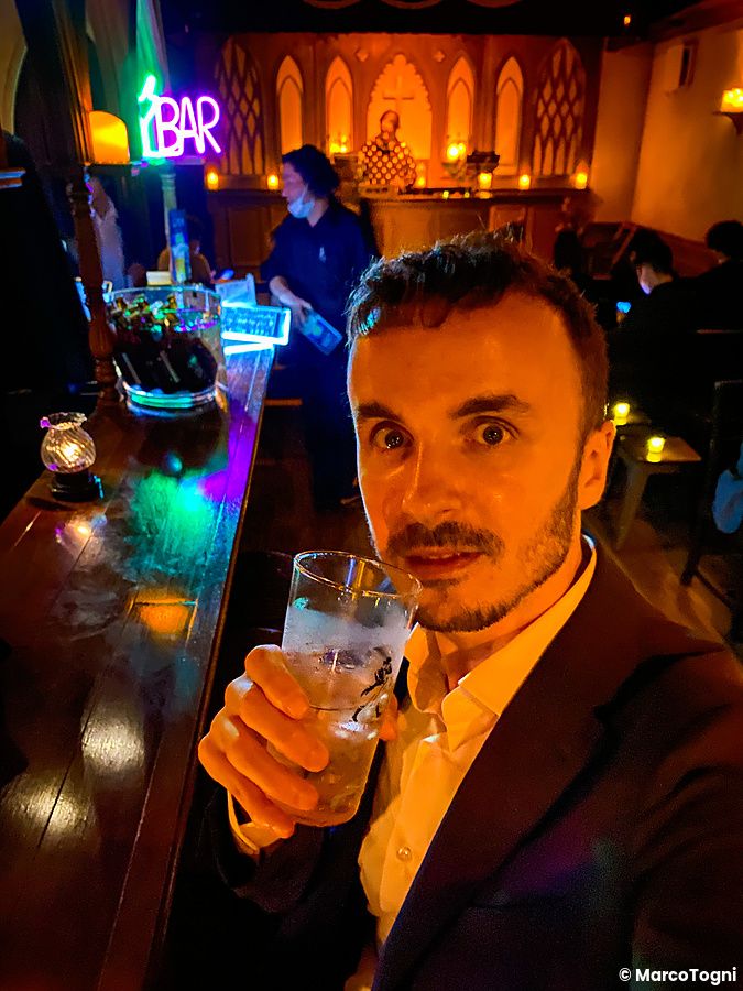 Marco Togni scatta un selfie all'interno del bar a tema The Church a Shibuya, circondato da arredi ispirati a una chiesa.