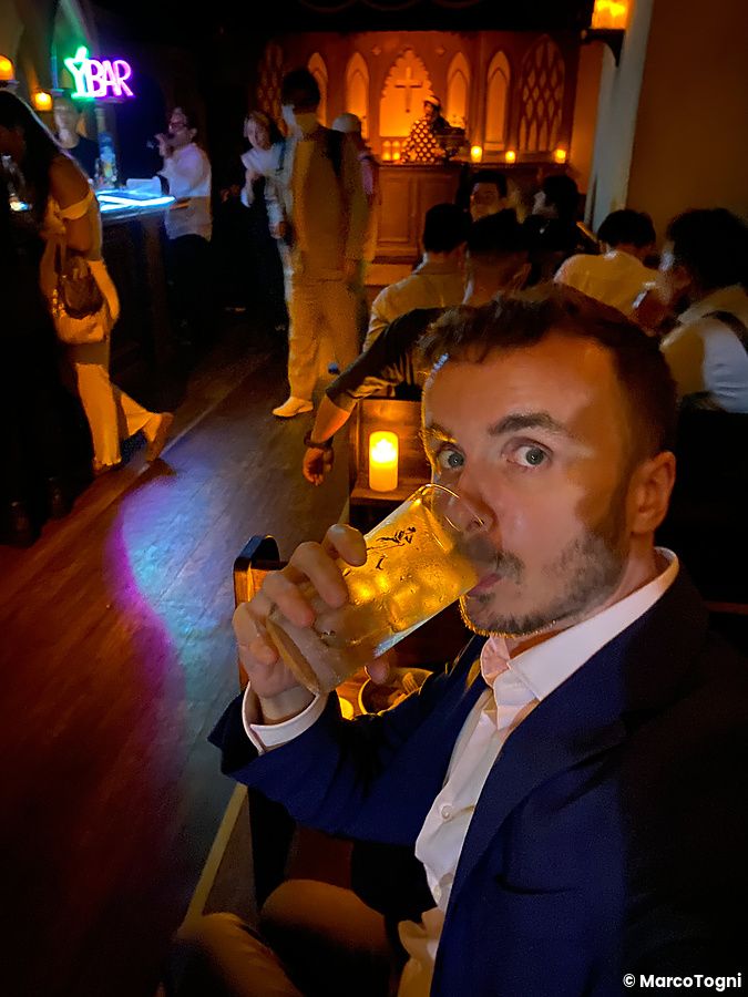 Marco Togni beve da un bicchiere all'interno di The Church, un bar a tema situato a Shibuya.