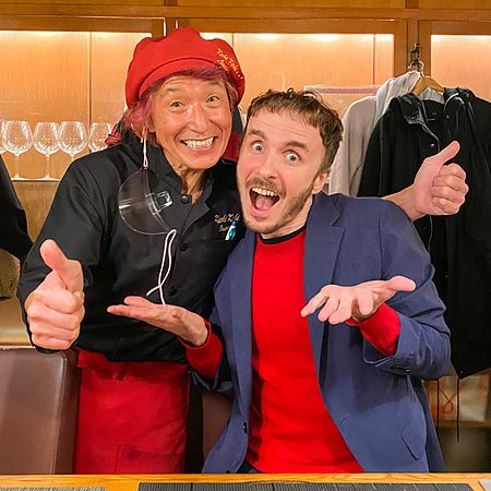 Marco Togni e un altro individuo sorridenti, tra cui lo chef, posano insieme all'interno del ristorante Kichi Kichi Omuric...