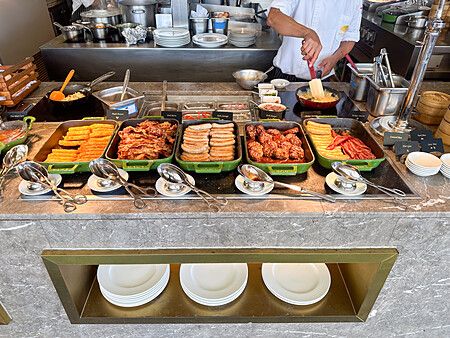 Colazione a buffet al Mandarin Oriental Bangkok con piatti vari e cuoco che prepara cibo.