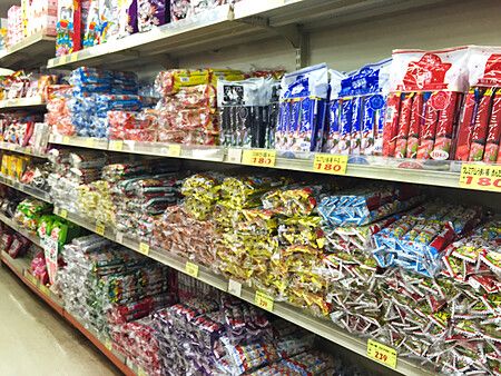 Scaffali pieni di snack colorati confezionati in vendita presso il negozio Niki no Kashi nel mercato di Ameyoko.