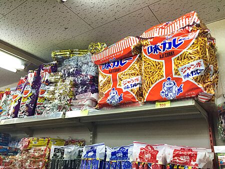 Scaffali pieni di snack colorati, inclusi pacchi di Aji Curry, all'interno del negozio Niki no Kashi a Ueno.