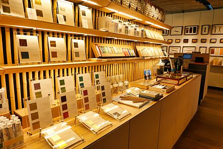 Interno del negozio Pigment a Tokyo con scaffali in bambù pieni di campioni di colore e materiali artistici.