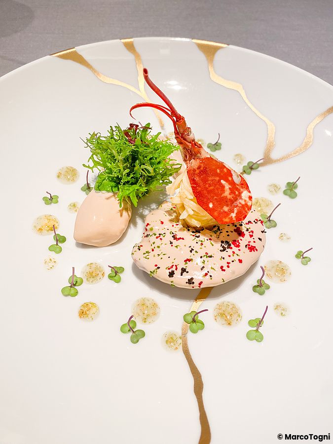 Aragosta con sedano rapa servita in un piatto decorato con venature dorate presso Asahina Gastronome a Tokyo.