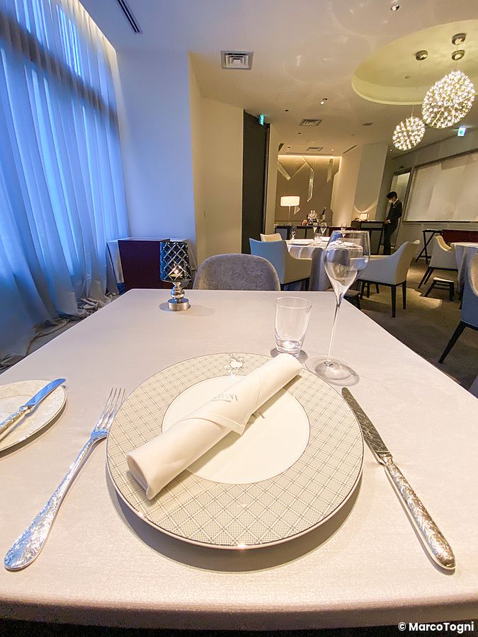 Una tavola elegantemente apparecchiata con una mise en place a Asahina Gastronome in un ristorante francese a Tokyo.