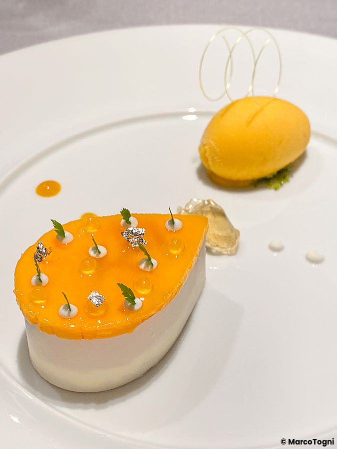 Dolce con mango di Miyazaki e frutto della passione servito su un piatto bianco al ristorante Asahina Gastronome.