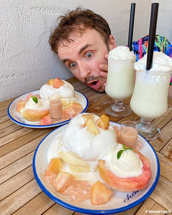Marco Togni guarda con stupore due piatti di pancake con pesche presso il ristorante Chaka.
