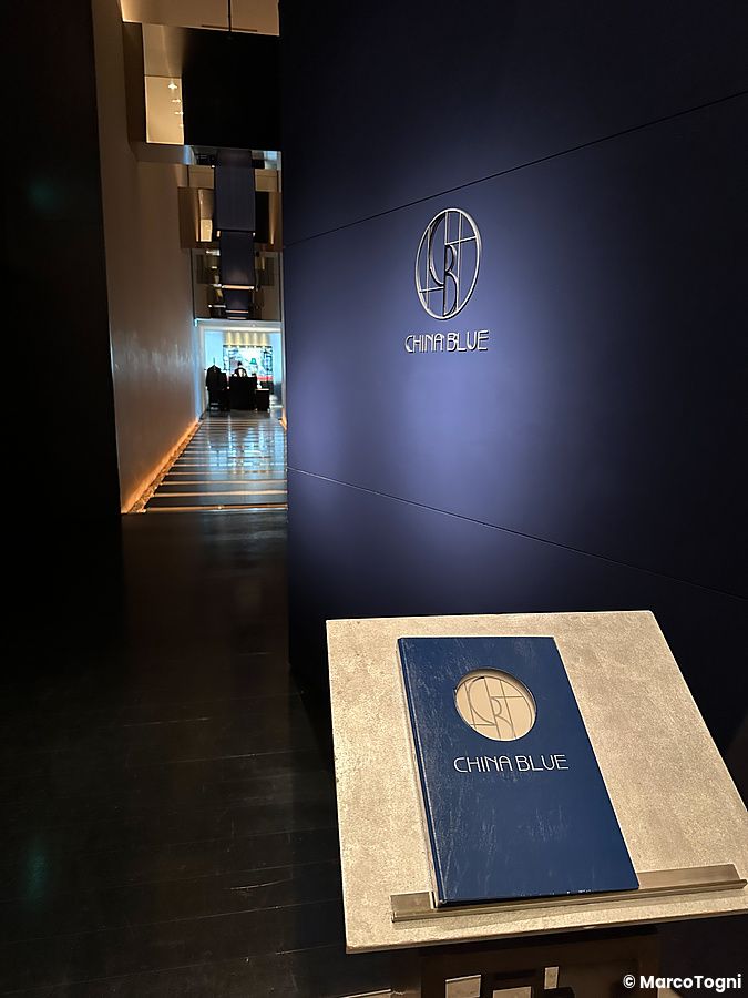 Ingresso del ristorante China Blue a Tokyo all'interno dell'hotel Conrad, con logo sulla parete e menù sul leggio.