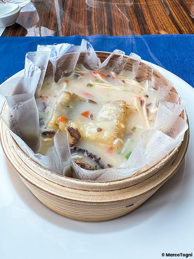 Filetto di pesce al vapore in brodo con funghi servito nel cestello di bambù al ristorante China Blue a Tokyo.