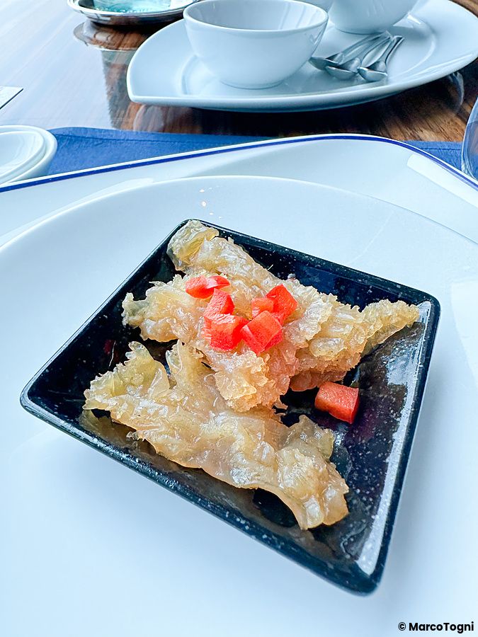 Un piatto di insalata di medusa guarnito con peperoni rossi servito al China Blue all'interno dell'hotel Conrad a Tokyo.