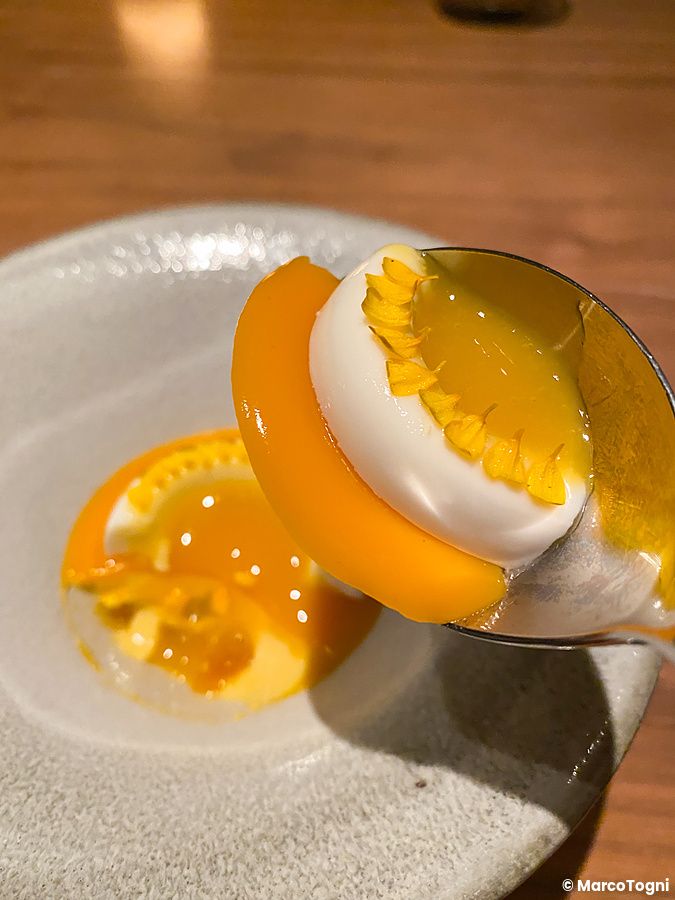 Dessert con crema bianca, coulis alla frutta e petali gialli servito al ristorante Crony, Tokyo.