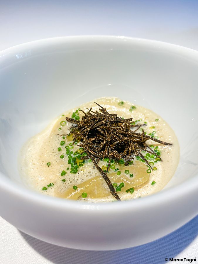 Ravioli con carciofi guarniti con tartufo nero e pepe giapponese serviti in una fondina bianca a L'Effervescense, Tokyo.