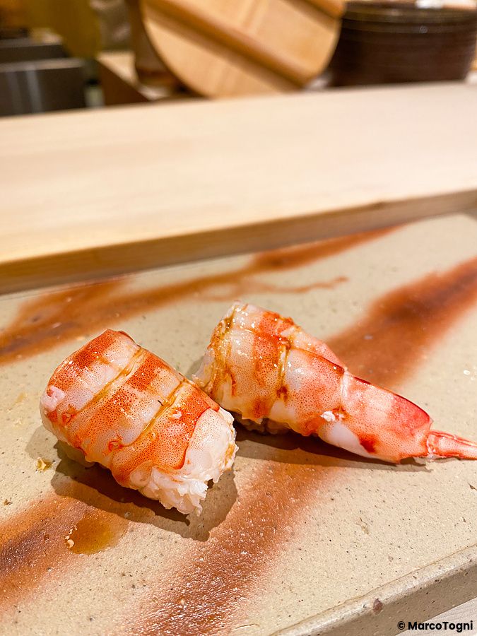 Due nigiri di kuruma ebi serviti su un piatto in ceramica presso il Sushi Ginza Onodera Souhonten a Ginza, Tokyo.