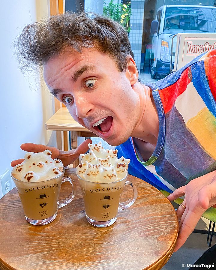 Marco Togni osserva due tazze di caffè con latte art su tavolino.