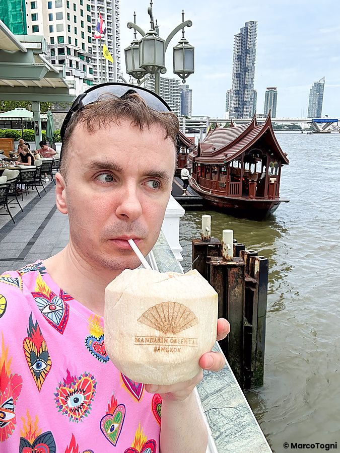 Marco Togni con cocco vicino al fiume al Mandarin Oriental Bangkok.
