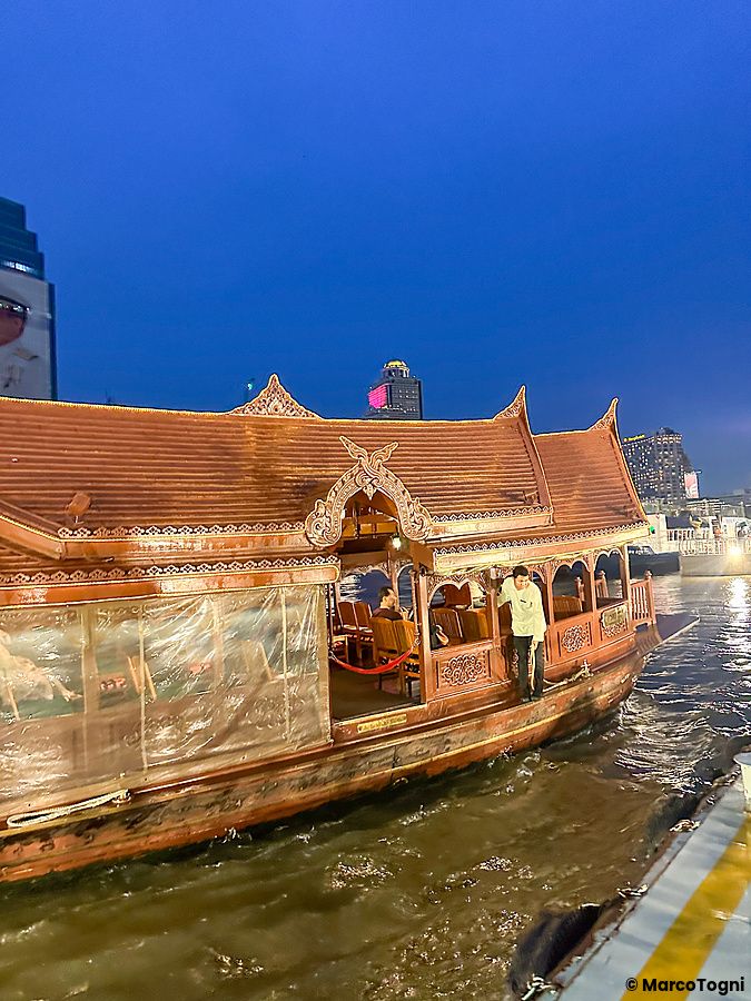 Una persona su una tradizionale imbarcazione di legno al fiume al Mandarin Oriental Bangkok.