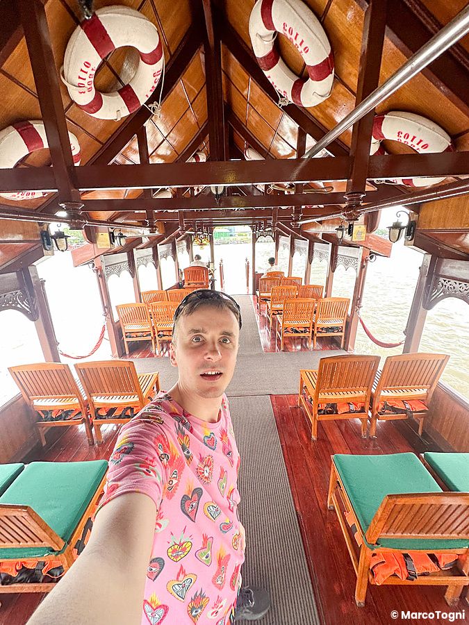 Marco Togni su un'imbarcazione dell'hotel al Mandarin Oriental Bangkok con sedili in legno.