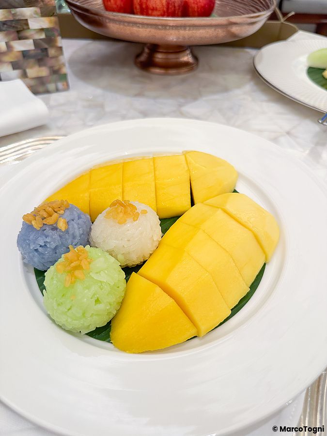 Mango sticky rice in camera al Mandarin Oriental Bangkok con mango fresco e riso colorato.