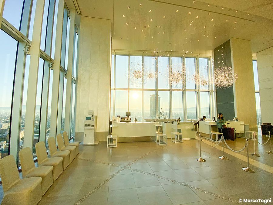 La hall del Osaka Marriott Miyako Hotel con ampie vetrate e lampadari eleganti.
