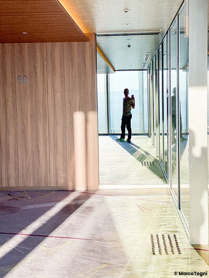Corridoio vicino alla zona ascensori al 51° piano di osaka marriott miyako hotel con individuo riflesso.