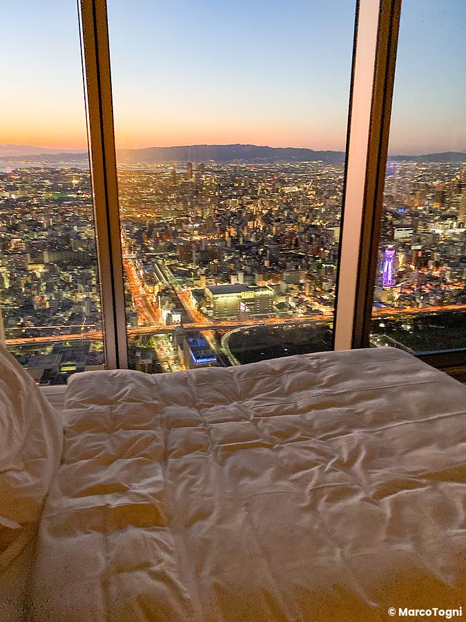 Vista dalla stanza (corner room) a Osaka Marriott Miyako Hotel con panorama urbano di Osaka al tramonto.