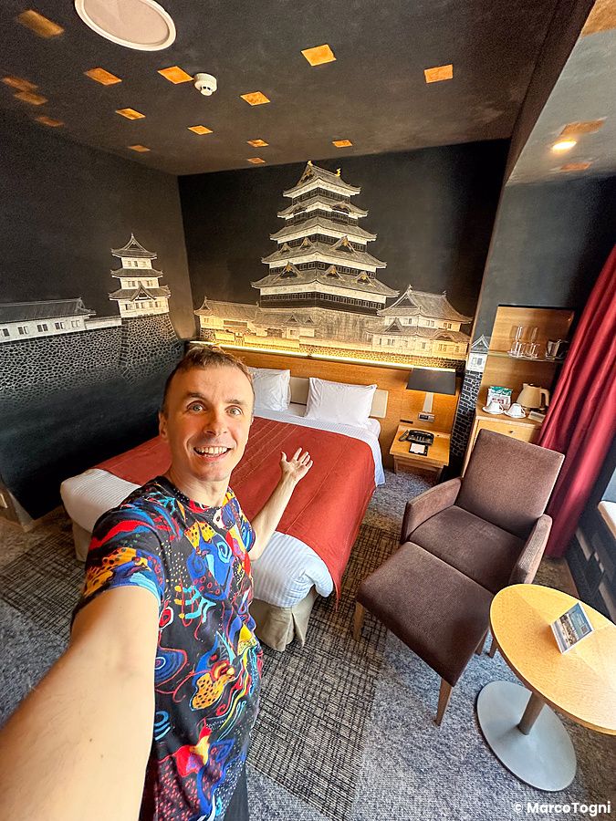 Marco Togni scatta un selfie in una stanza artistica con un dipinto di un castello giapponese al Park Hotel Tokyo.
