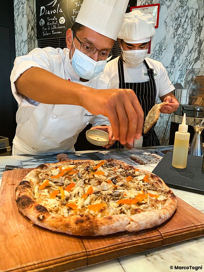Un pizzaiolo rifinisce una pizza ai funghi a The Pizza Bar On 38th presso il Mandarin Oriental Hotel a Tokyo.
