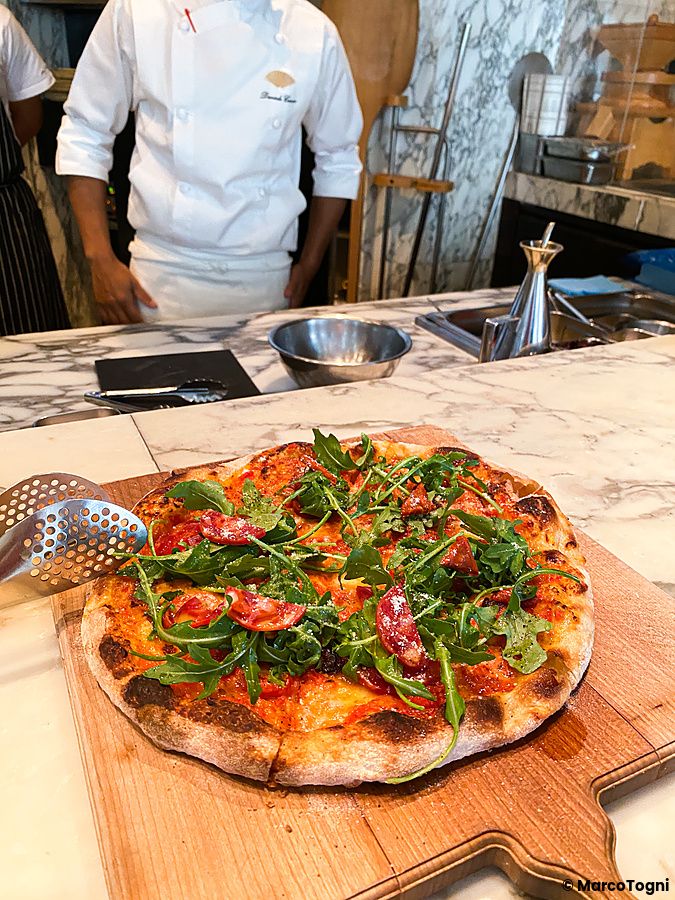 Una pizza con salame e rucola su un tagliere di legno al The Pizza Bar On 38th nel Mandarin Oriental Hotel di Tokyo.