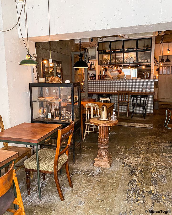 Interno del ristorante indiano Sajilo Clove a Nishi Ogikubo con tavoli, sedie e bancone cucina sullo sfondo.