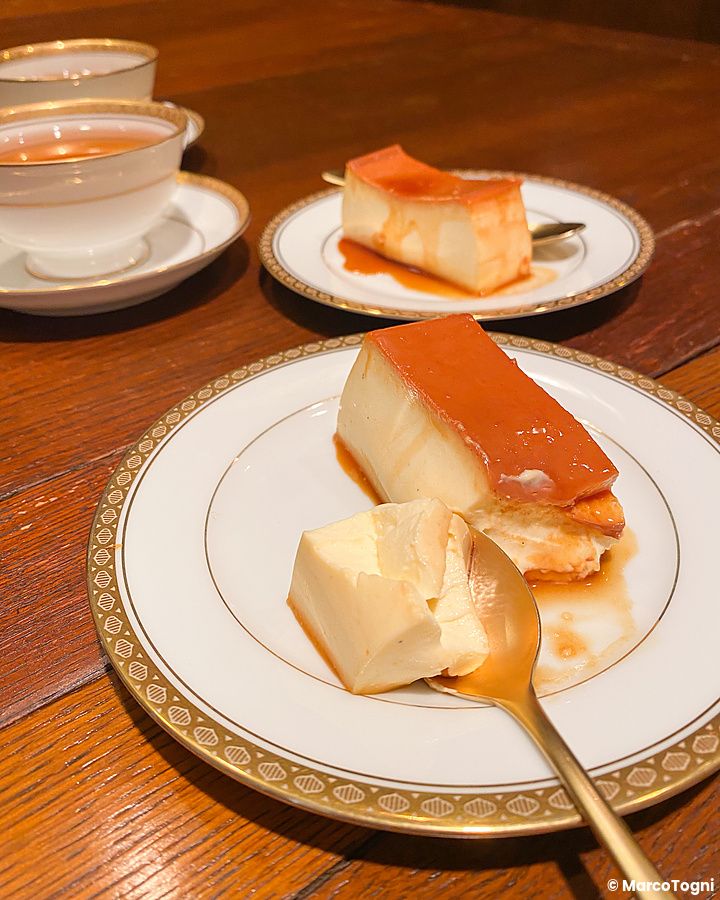 Due fette di budino con caramello su piatti di porcellana al Satella, una caffetteria tradizionale di Shibuya a Tokyo.