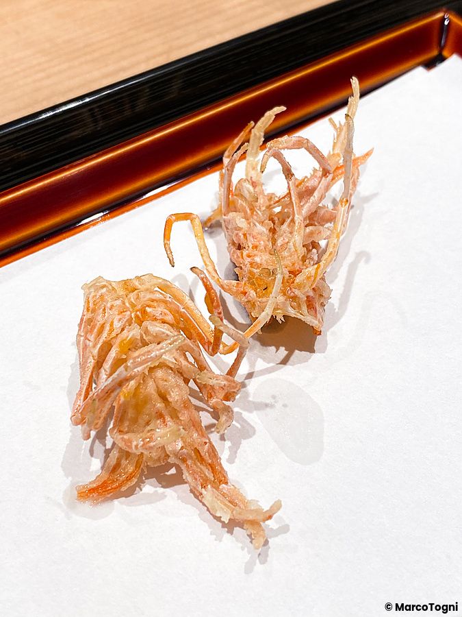 Due pezzi di gambero a Tempura Kondo fritti con tecnica tempura, adagiati su carta bianca in un ristorante a Ginza.