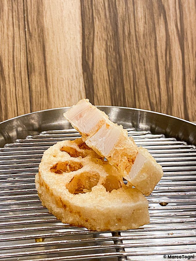 Tempura di radice di loto servita su una griglia metallica circolare al ristorante Tempura Shimomura a Tokyo.