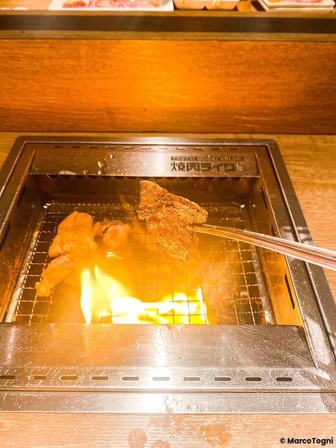 Carne grigliata su piastra metallica incassata in un tavolo presso il ristorante Yakiniku Like.