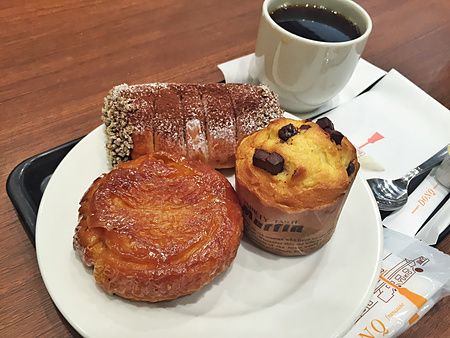Prodotti da forno tra cui un muffin e una sfoglia su un piatto, serviti presso una caffetteria Donq in Giappone.