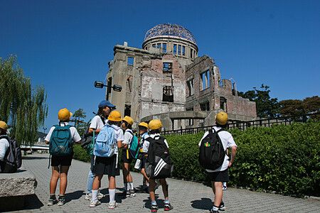 Bambini con cappelli gialli davanti al Hiroshima Peace Memorial.