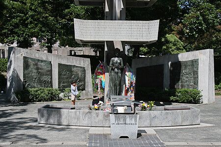 Un bambino osserva un monumento in bronzo dedicato agli studenti nel Parco della Pace di Hiroshima in Giappone.