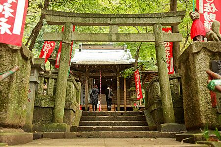 Due persone davanti a un torii nel Sasuke Inari a Kamakura.