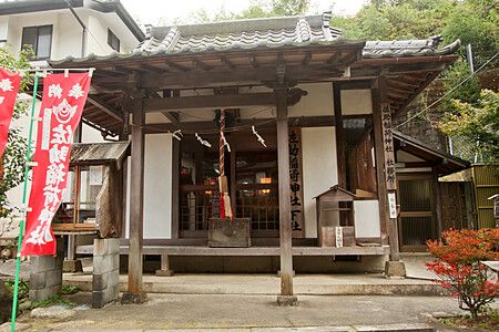 Santuario Sasuke Inari a Kamakura con struttura in legno e striscioni rossi.