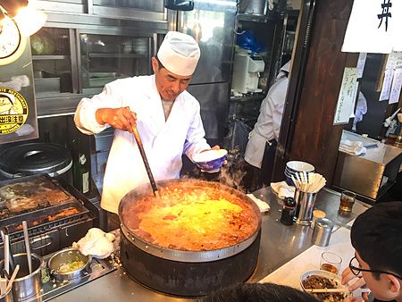 Cuoco che prepara gyudon al ristorante Kitsuneya a Tsukiji, Tokyo.