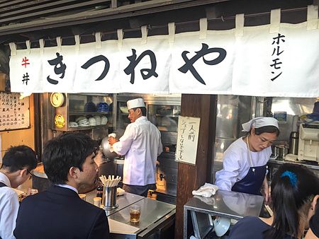 Clienti al ristorante Kitsuneya di Tsukiji mangiano in piedi.