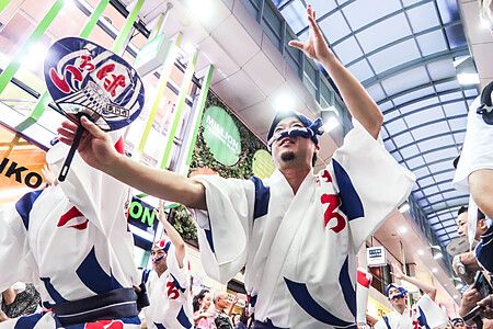 Gruppo di persone danza con ventagli tradizionali al Koenji Awa Odori.