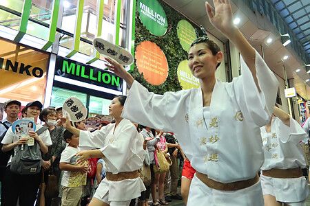 Persone che ballano al Koenji Awa Odori di Tokyo indossando abiti tradizionali bianchi.
