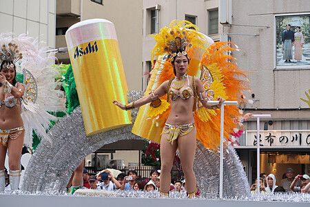Performer in costume samba su carro con birra Asahi all'Asakusa Samba Carnival.