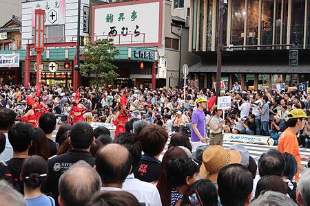 Folla durante Asakusa Samba Carnival a Tokyo con danzatori in costumi colorati.