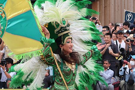 Performer in costume verde e oro durante l'Asakusa Samba Carnival a Tokyo.